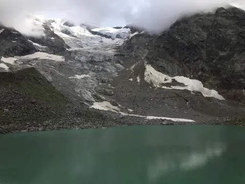 Il lago delle Locce sotto il ghiacciaio in una giornata nuvolosa