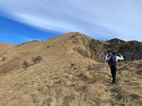Un escursionista sulla cresta erbosa del monte Cerano